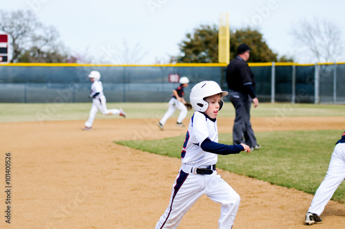 Youth baseball player running bases.