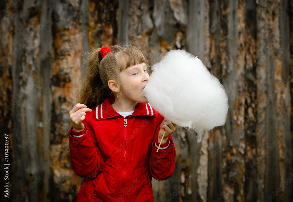 Beautiful little girl eating candy floss (cotton candy). Beautiful little girl eating candy floss (cotton candy).