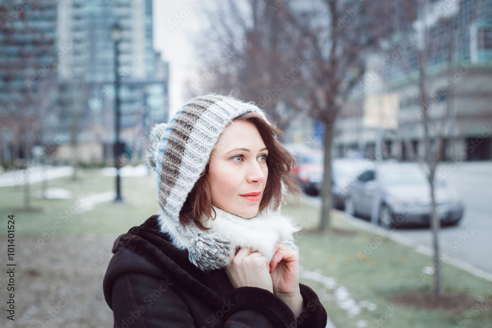 Closeup portrait of beautiful romantic brunette Caucasian woman in knitted hat looking away from camera outside on cold winter day Closeup portrait of beautiful romantic brunette Caucasian woman in knitted hat looking away from camera outside on cold winter day
