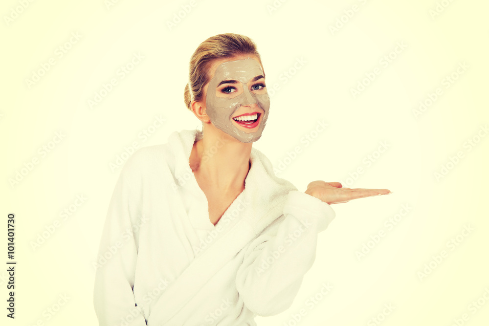 Young woman with facial mask holding something on her hand Young woman with facial mask holding something on her hand
