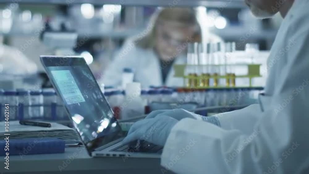 Male scientist is working on a laptop computer in a laboratory. Shot on RED Cinema Camera. Male scientist is working on a laptop computer in a laboratory. Shot on RED Cinema Camera.