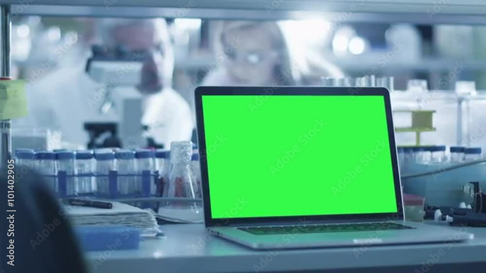 Footage of a laptop computer with green screen on a table in a laboratory. Shot on RED Cinema Camera.