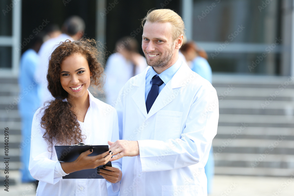 Medical concept - two doctors with stethoscopes and prescription clipboard Medical concept - two doctors with stethoscopes and prescription clipboard