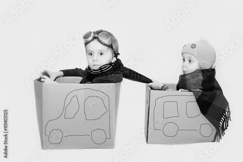 Creative boys plays with cardboards cars.