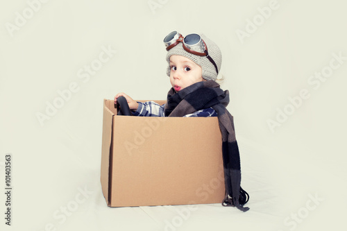 Creative boy plays with his cardboard car.