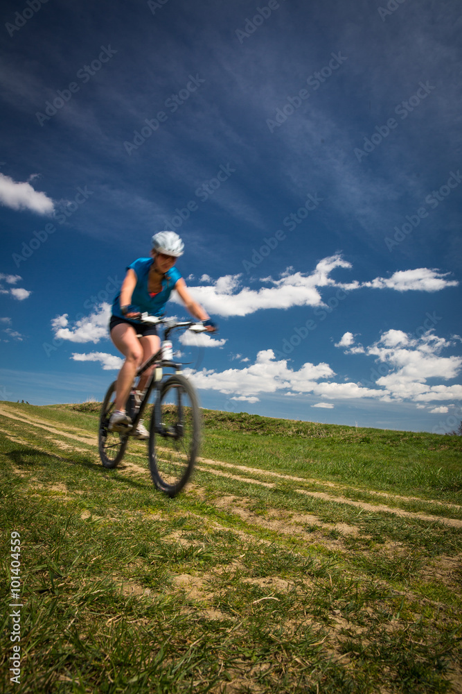 Pretty, young female biker outdoors on her mountain bike 