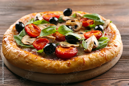 Delicious tasty pizza with ingredients on wooden table