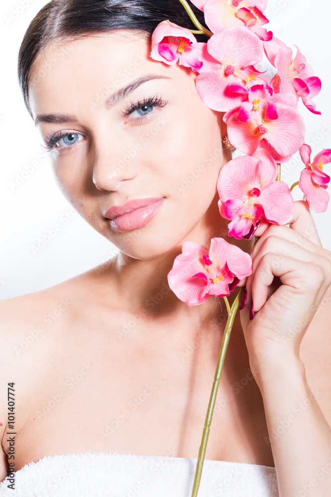Beautiful woman holding a branch of orchid flowers Beautiful woman holding a branch of orchid flowers