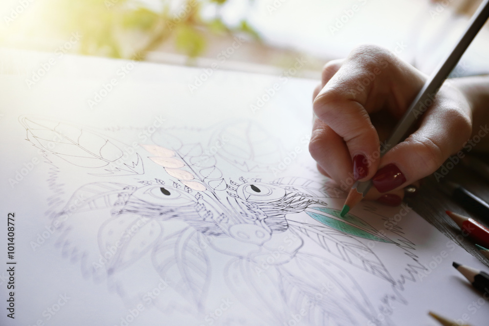 Female hand painting anti stress colouring with green pencil Female hand painting anti stress colouring with green pencil