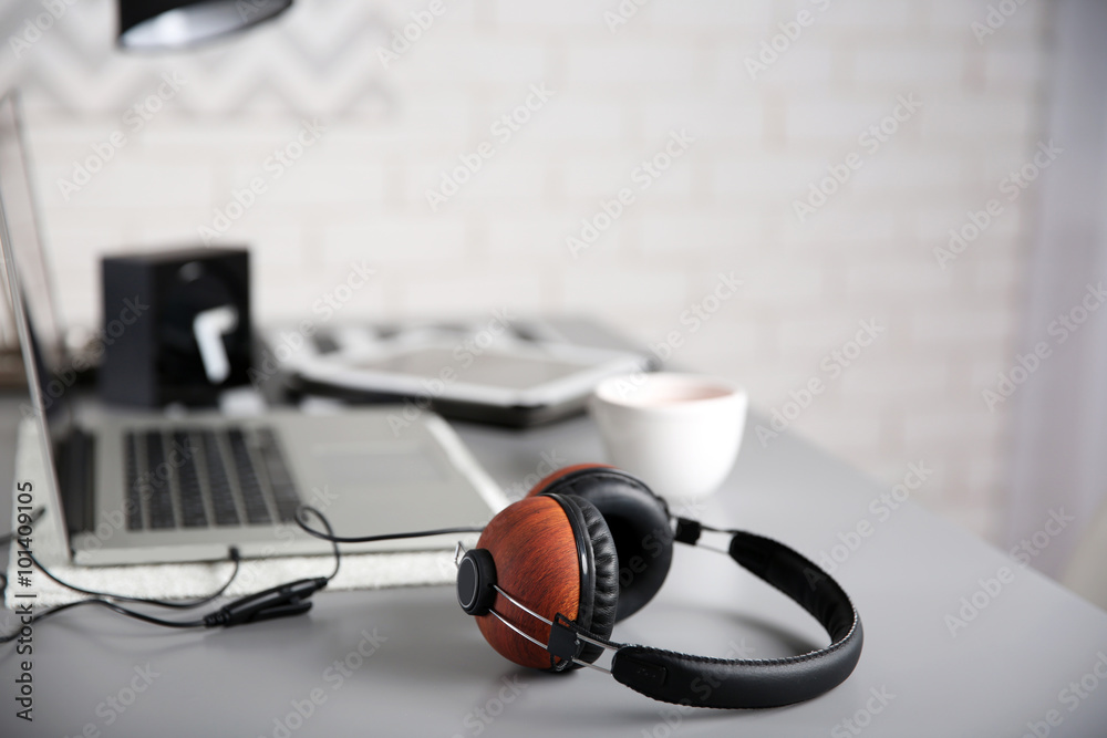 Headphones and laptop on gray table against defocused background Headphones and laptop on gray table against defocused background