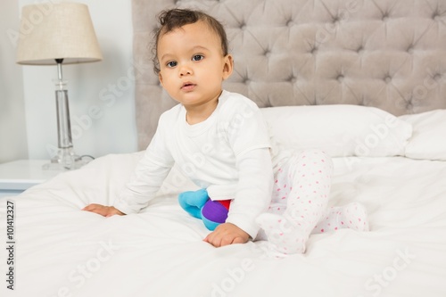 Cute baby sitting on bed
