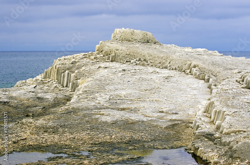 Freakish rock on cape Stolbchaty, island Kunashir, the Kuril ridge, Russia photo
