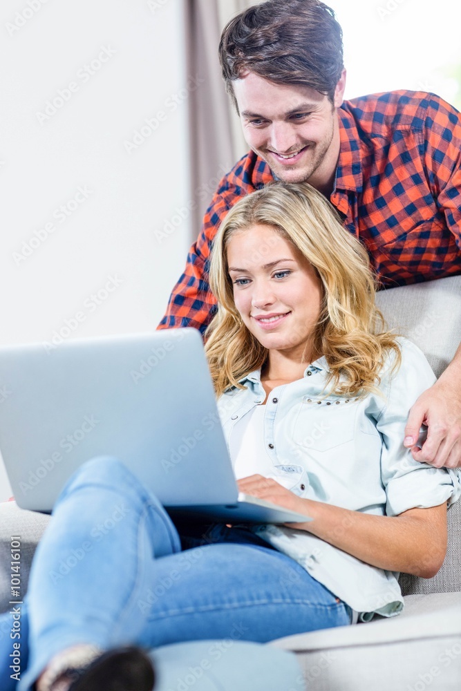 Couple using laptop on the couch Couple using laptop on the couch