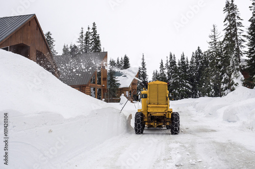 Mountain Cabin Road with Yellow Snow Removal Machine