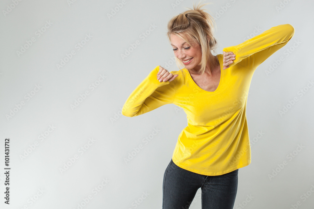 Φωτογραφία success concept - dynamic 20s blond woman with yellow shirt smiling with arms ra