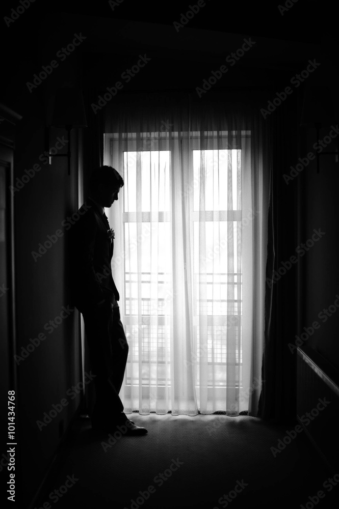 the figure of a man standing in the dark hallway groom the figure of a man standing in the dark hallway groom