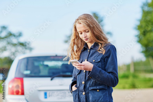 Woman on the road near a broken car calling for help