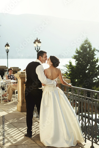 Happy married couple husband and whife hugging at stone balcony photo