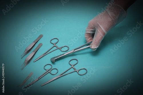 Hand and various scissors on blue background