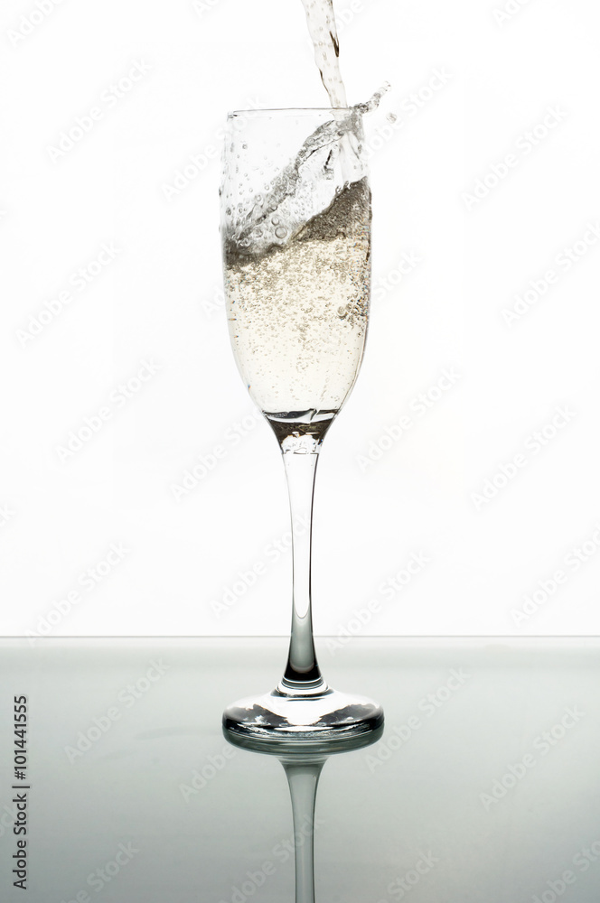 Obraz premium Pouring champagne into glass on white background