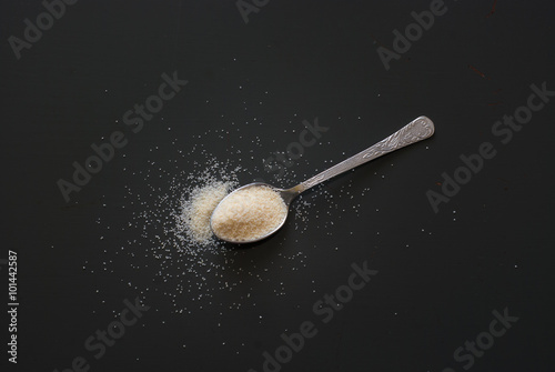 semolina on metal spoon on dark wooden table