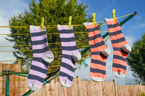 Two pairs of striped socks hanging on the washing line outside photo