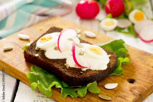 Toast sandwich with egg, radish, pumpkin seeds and sour cream, s