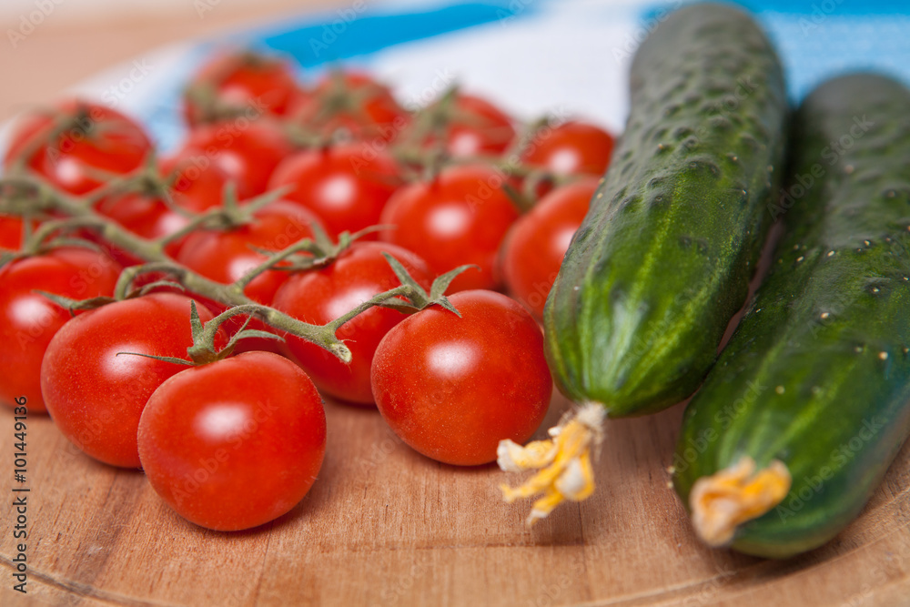 cherry tomatoes and cucumbers on a wooden background cherry tomatoes and cucumbers on a wooden background