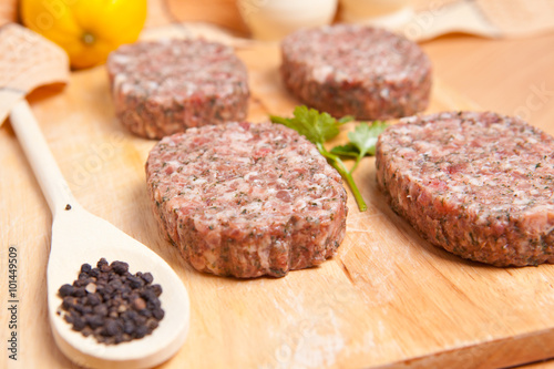 raw patties with spices on a cutting board