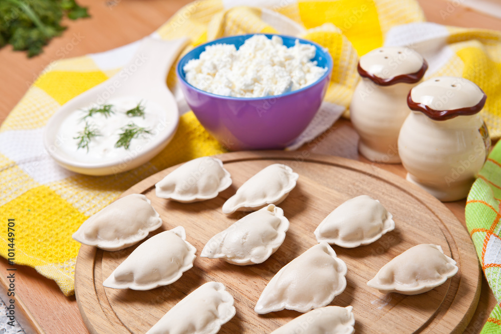 raw dumplings on a cutting board with cheese raw dumplings on a cutting board with cheese