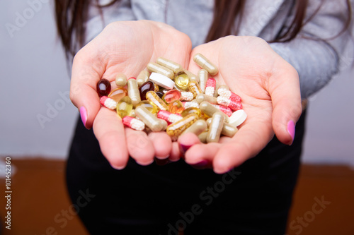 lot of pills and capsules in female hands