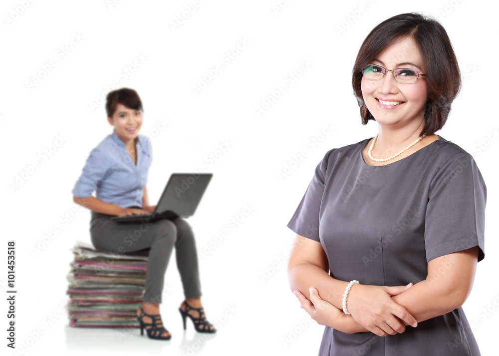 mature business women standing with her secretary behind holding mature business women standing with her secretary behind holding