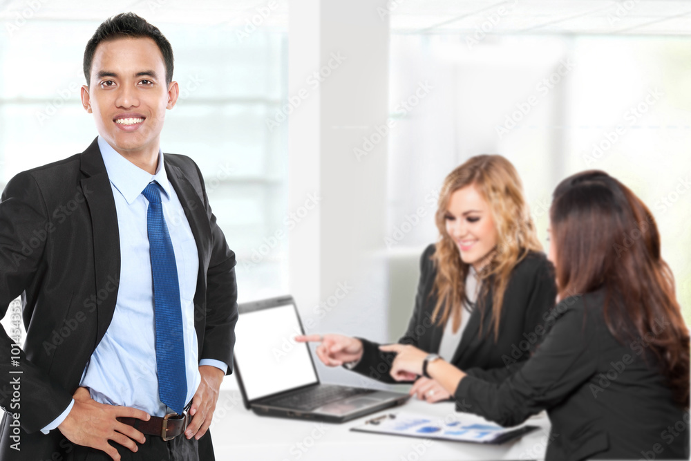 Young asian businessman, with his team behind. isolated in white Young asian businessman, with his team behind. isolated in white