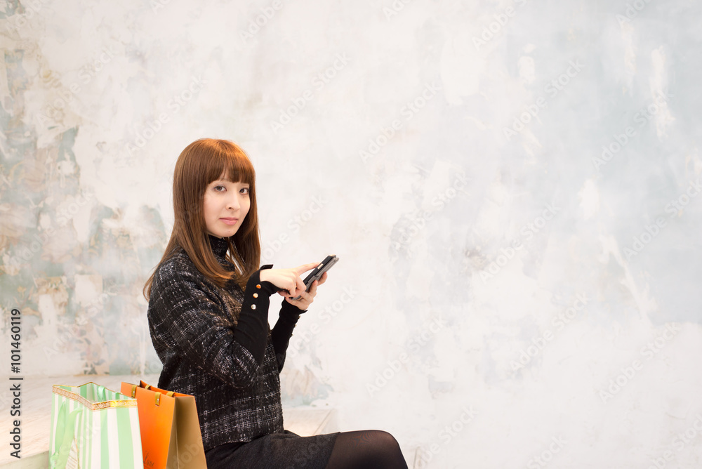 Obraz premium Japanese girl killing time with shopping bag
