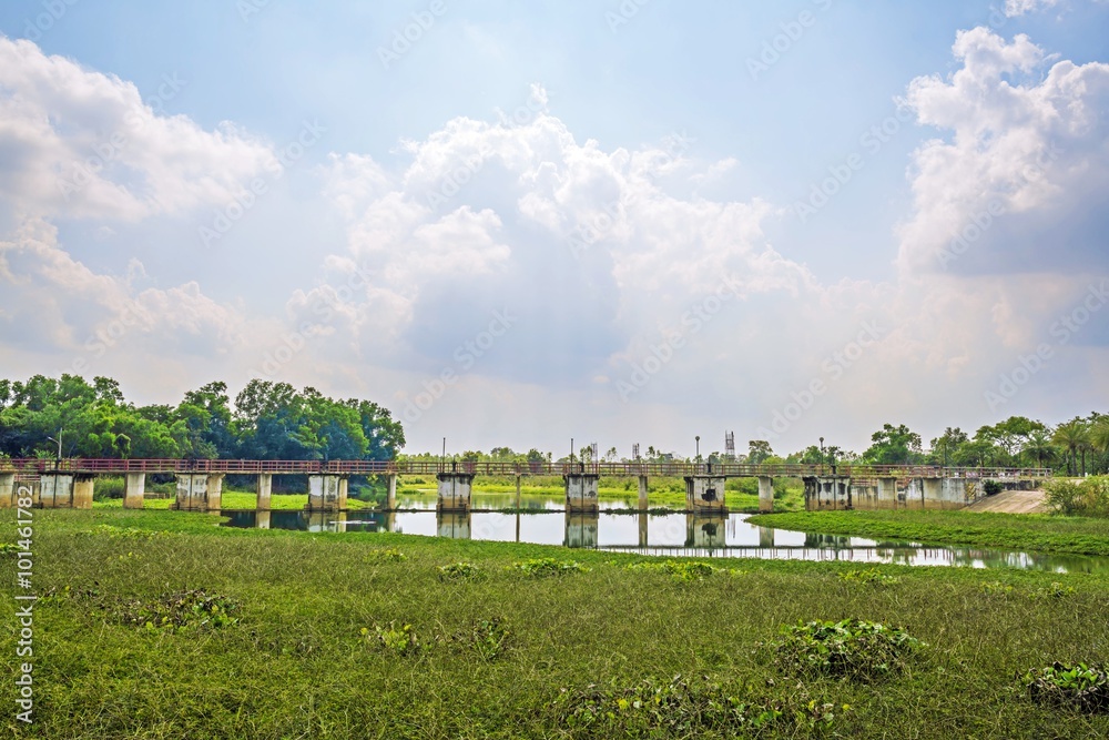  Landscape photograph of Water rushing through gates with water hyacinth at a dam and beautiful sky clouds
