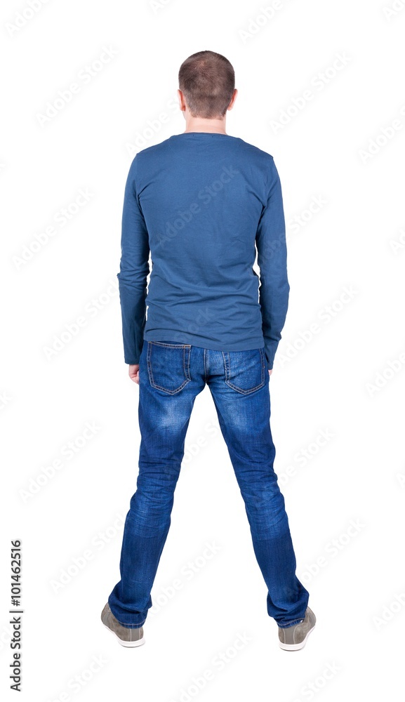Back view of young man in t-shirt and jeans  looking