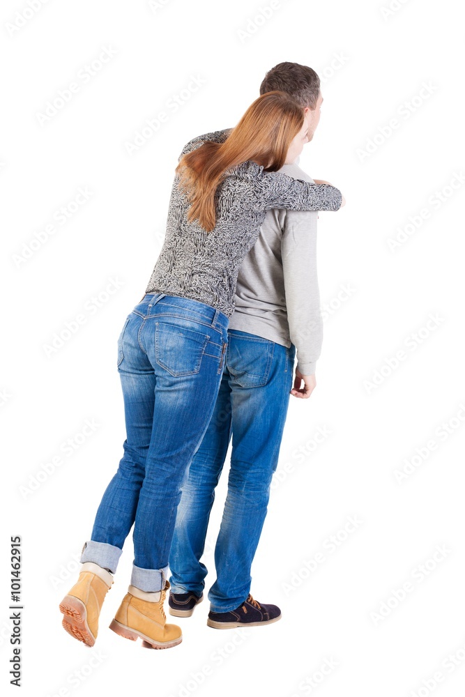 Back view of young embracing couple (man and woman) hug and look Back view of young embracing couple (man and woman) hug and look