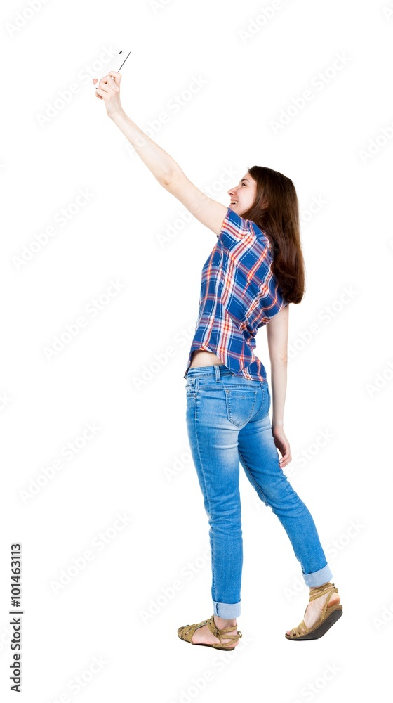 back view of standing young beautiful woman and using a mobile back view of standing young beautiful woman and using a mobile