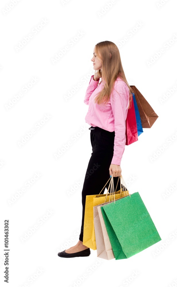 back view of going  woman  with shopping bags