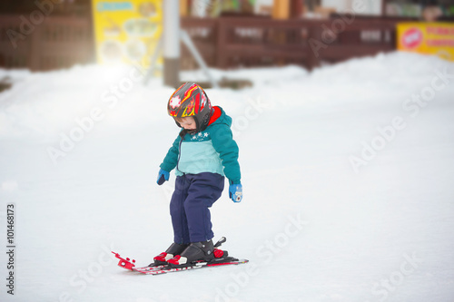 toddler boy skiing in the mountains, winter time