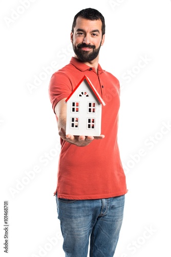 Handsome man holding a little house