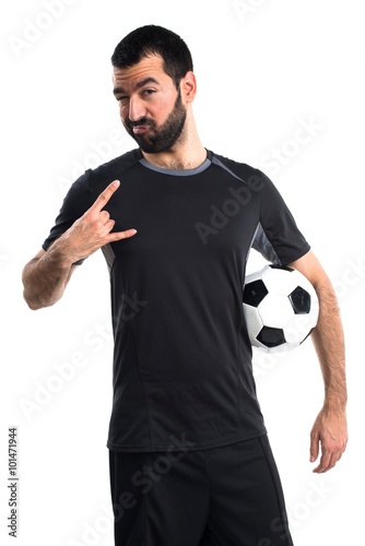 Football player making horn gesture © luismolinero