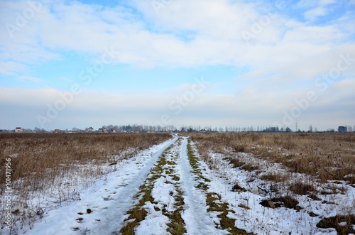 dirt path,the road from the snow across the field