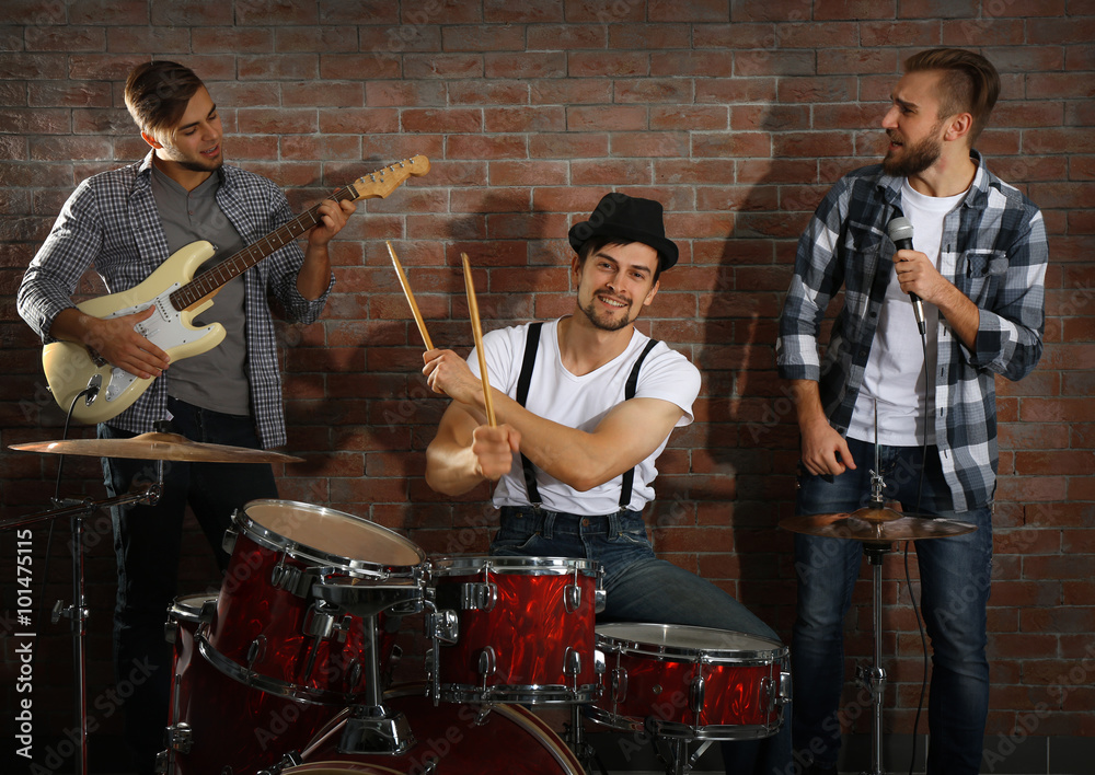 Fotografie Musicians playing the drums on brick wall background