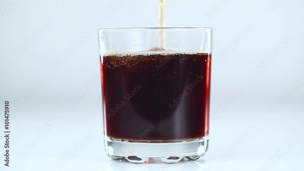 Fizzy drink is poured into a glass. White background. Close-up Fizzy drink is poured into a glass. White background. Close-up