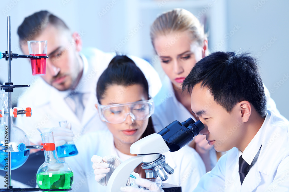 Young medical technicians working in laboratory Young medical technicians working in laboratory
