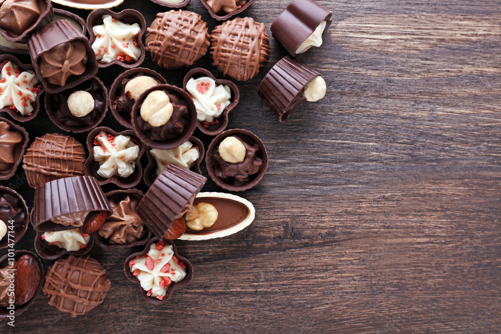 Delicious chocolate candies on wooden background, close up