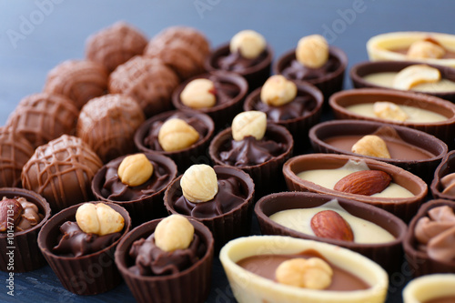 Delicious chocolate candies on blue wooden background, close up