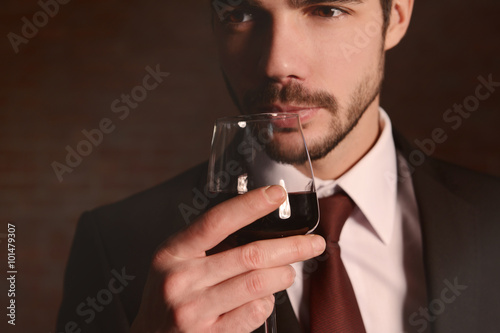 Man sniffing red wine in glass