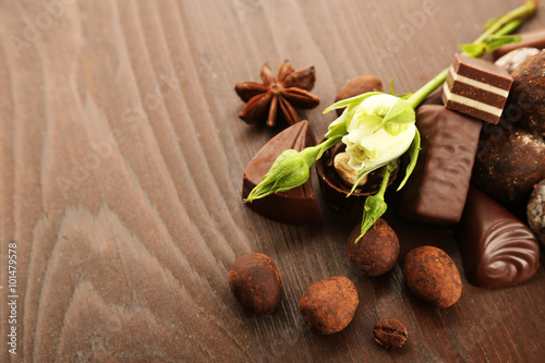 Assorted chocolate candies on a wooden background, close up